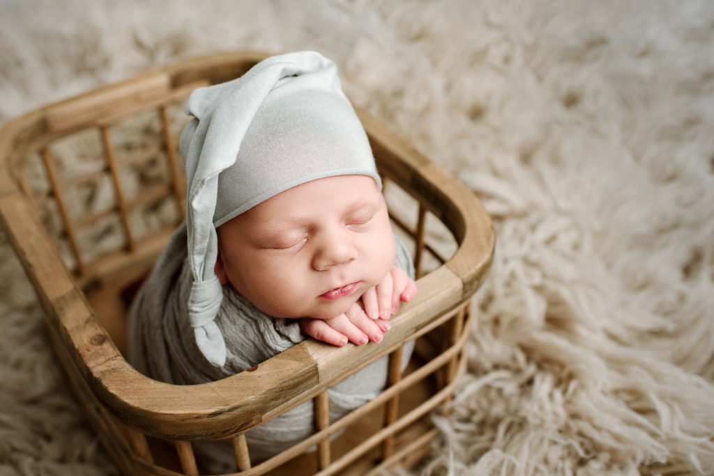 Baby boy with sleepy cap in crate in Jacksonville Beach, FL