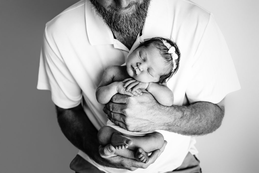 Black and white portrait of dad holding baby girl in Jacksonville, FL