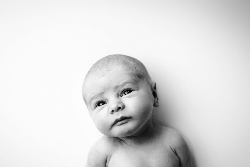 Black and white in home studio portrait of newborn with eyes open in Ponte Vedra, Florida.