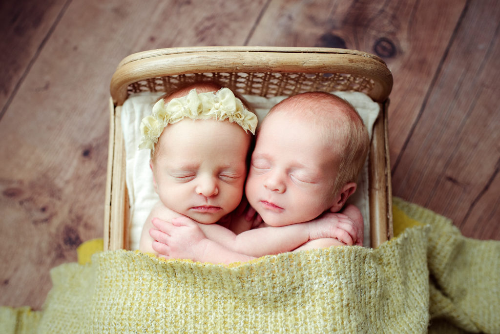 Newborn girl and boy twins snuggling under yellow blanket in San Marco Jacksonville, FL.